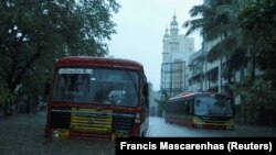 Bus penumpang terdampar di jalan yang tergenang air setelah hujan lebat akibat Topan Tauktae di Mumbai, India, 17 Mei 2021. (Foto: REUTERS/Francis Mascarenhas)
