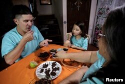 Pakar biologi Frederico Panigua dan keluarga menyantap kudapan dari serangga-serangga untuk mempromosikan serangga sebagai makanan bergizi dan mura, di Grecia, Kosta Rika, 13 Juli 2019. (Foto: Reuters)