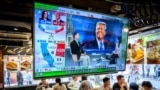 TOPSHOT - A TV screen showing preliminary results about the US elections hangs in a restaurant in Hong Kong on November 6, 2024.