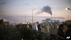 France Migrants: Migrants wait to register outside a processing center in the makeshift migrant camp known as "the jungle" near Calais, northern France, Wednesday, Oct. 26, 2016.