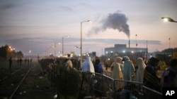 Des migrants attendent pour s’inscrire à l’extérieur d'un centre de traitement dans le camp de migrants de fortune appelé "la jungle" près de Calais, dans le nord de la France, 26 octobre 2016.