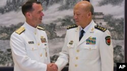 U.S. Chief of Naval Operations Adm. John Richardson (L) and Commander of the Chinese navy, Adm. Wu Shengli shake hands at Chinese Navy Headquarters in Beijing, China, July 18, 2016.