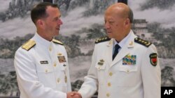 존 리처드슨(왼쪽) 미국 해군참모총장과 우성리 중국 해군 사령원이 18일 베이징 회담에 앞서 악수하고 있다.
