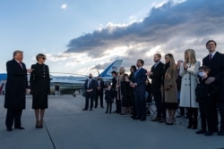 U.S. President Donald Trump and first lady Melania Trump greet family members stand on the tarmac at Joint Base Andrews in Maryland, Jan. 20, 2021.