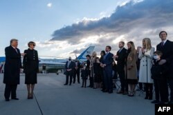 U.S. President Donald Trump and first lady Melania Trump greet family members stand on the tarmac at Joint Base Andrews in Maryland, Jan. 20, 2021.