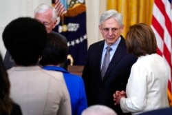 Attorney General Merrick Garland talks with House Speaker Nancy Pelosi of California before the signing of the COVID-19 Hate Crimes Act, in the East Room of the White House, May 20, 2021.
