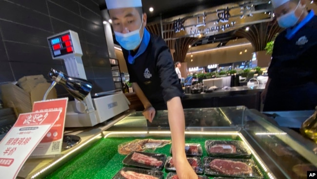 北京一名超市工作人员为牛肉贴上销售标签。2020年8月28日图片。