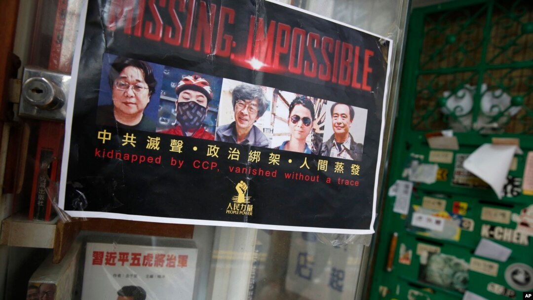 Poster bergambar lima penjual buku Hong Kong yang hilang, ditempelkan oleh pendukung mereka di pintu masuk Toko Buku Causeway Bay di Hong Kong (5/2). (AP/Kin Cheung)