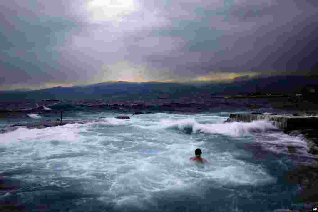 Seorang pria berenang di Laut Tengah di pantai Beirut, Lebanon.