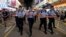 Police officers instruct street entertainers and spectators to leave on the last day before the Mong Kok's pedestrian zone closure in Hong Kong, July 29, 2018. 