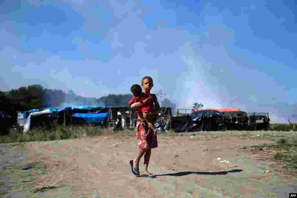 A boy and a baby are seen after the eviction of a settlement of homeless people set up during the Covid-19 pandemic in land owned by the Brazilian Oil Company Petrobras, in Itaguai, Rio de Janeiro state.
