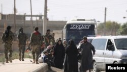 People gather along a road as they flee Raqqa, Syria, Oct. 16, 2017.