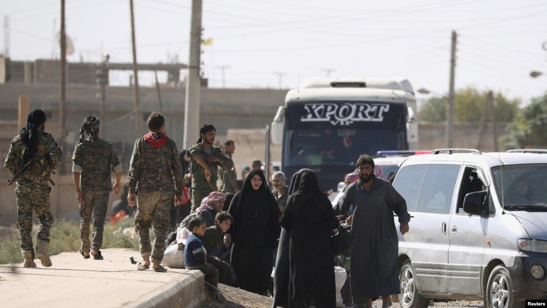 Warga berkumpul di sepanjang jalan, saat melarikan diri dari Raqqa, Suriah, 16 Oktober 2017.
