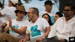 FILE - Rebel leaders Rodrigo Londono, center, Ivan Marquez, right, and Pastor Alape, left, attend the closing event of the 10th conference of the Revolutionary Armed Forces of Colombia, FARC, in Yari Plains, Colombia, Sept. 23, 2016.