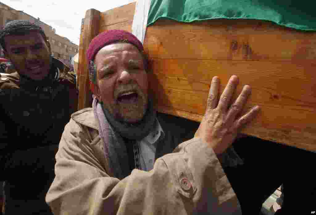 A mourner carries a coffin containing the body of a rebel killed in clashes with forces loyal to Libyan leader Muammar Gaddafi in Ras Lanuf, during his funeral in Benghazi March 9, 2011.