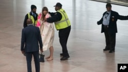 National Gallery of Art security cover Radical Matriarchy member Laura Newman with a blanket after she removed her clothes and sang during a protest in the museum, Feb. 14, 2019 in Washington. 
