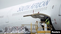 FILE - A worker looks on as the second delivery of the Johnson & Johnson COVID-19 vaccine is offloaded at the O.R Tambo International Airport in Johannesburg, South Africa, Feb. 27, 2021. (Kim Ludbrook/Pool via Reuters)