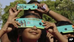 Indian children use cardboard eclipse glasses as they prepare to watch the transit of Venus in Allahabad, India, June 5, 2012.