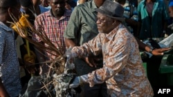 Tanzanian President John Magufuli joins a clean-up event outside the State House in Dar es Salaam on Dec. 9, 2015. Magufuli cancelled Independence Day celebrations and ordered a national day of clean-up instead.
