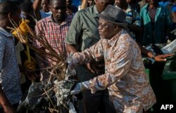 President John Magufuli joins a clean-up event outside the State House in Dar es Salaam, Dec. 9, 2015.