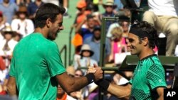 El suizo Roger Federer (derecha) estrecha la mano del argentino Juan Martín del Potro, tras vencerlo en el Abierto de Miami, el lunes 27 de marzo de 2017.