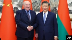 资料照片: 2023年12月4日中国国家主席习近平(右)在北京与来访的白俄罗斯总统卢卡申科握手