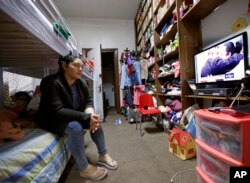 FILE - Amanda Morales, a Guatemalan immigrant living illegally in the United States, watches a nightly news program, inside a small converted classroom and library, at the Holyrood Episcopal Church in northern Manhattan, where she has sought sanctuary with her three children, Oct. 26, 2017.