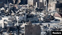 A view of burnt vehicles and ruins of houses gutted by a fire caused by fighting between government soldiers and Muslim rebels from the Moro National Liberation Front (MNLF) in Zamboanga city in southern Philippines, Sept. 13, 2013. 