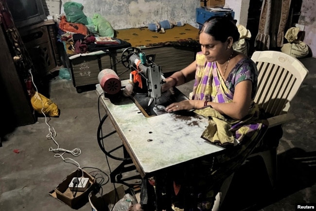 Reena Ben works on a solar-powered sewing machine to stitch clothes inside her one-room house in Modhera, India's first round-the-clock solar-powered village, in the western state of Gujarat, India, October 19, 2022. (REUTERS/Sunil Kataria)