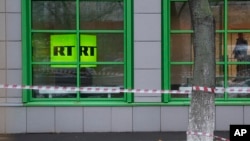 Logo saluran televisi milik negara Rusia RT terlihat di jendela kantor perusahaan di Moskow, Rusia, 27 Oktober 2017.