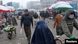 지난 3일 아프가니스탄 수도 카불 시내에 눈이 내리는 가운데 주민들이 걷고 있다. (자료사진)