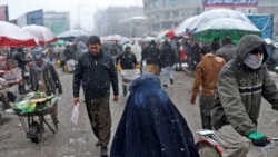 ژنێکی ئەفغانی لە شەقامێکی سەرەکی کابوڵ بە بەفر و سەرما، 3ی مانگی یەکی 2022