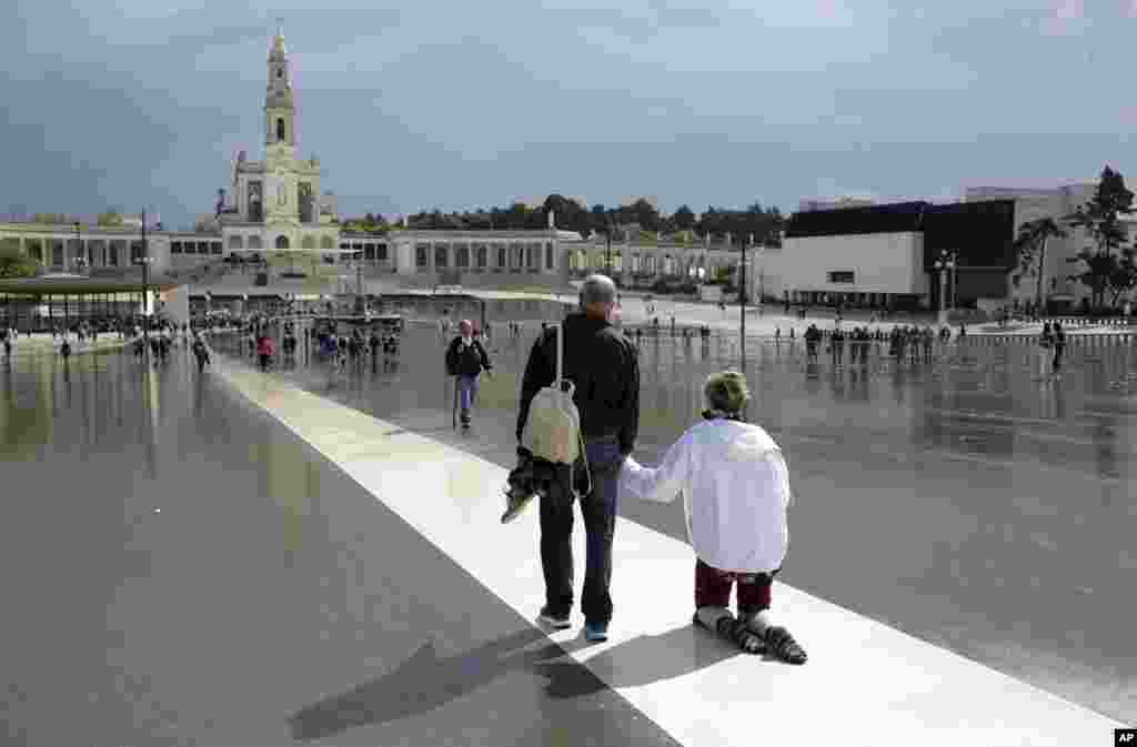 A pilgrim walks on her knees paying penance at the Fatima sanctuary in Fatima, Portugal.