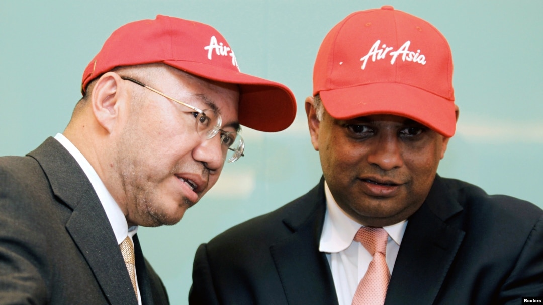 Pendiri AirAsia X Tony Fernandes (Kanan) mendengarkan Ketua AirAisa Kamarudin Meranun saat upacara penandatanganan pesawat Airbus A330-200s baru di Kuala Lumpur, Malaysia, 28 Februari 2011. (Foto: Reuters)