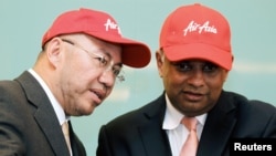 Pendiri AirAsia X Tony Fernandes (Kanan) mendengarkan Ketua AirAisa Kamarudin Meranun saat upacara penandatanganan pesawat Airbus A330-200s baru di Kuala Lumpur, Malaysia, 28 Februari 2011. (Foto: Reuters)