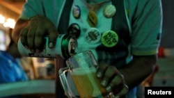 FILE PHOTO: A waiter pours Carlsberg beer at a pub in Mumbai