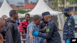 Rwanda security officials check people crossing from Congo in Gyseny, Rwanda, Jan. 28, 2025, following M23 rebels' advances into eastern Congo's capital Goma.