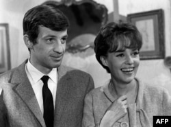 FILE - French actor Jean-Paul Belmondo (L) speaks with actress Jeanne Moreau in Paris, Jan. 1, 1963.