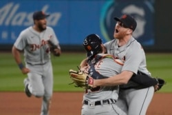 Detroit Tigers starting pitcher Spencer Turnbull, right, hugs catcher Eric Haase as teammates rush in after Turnbull threw a no-hitter in a baseball game against the Seattle Mariners, Tuesday, May 18, 2021, in Seattle. The Tigers won 5-0. (AP Photo/Ted S. Warren)