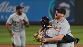 Detroit Tigers starting pitcher Spencer Turnbull, right, hugs catcher Eric Haase as teammates rush in after Turnbull threw a no-hitter in a baseball game against the Seattle Mariners, Tuesday, May 18, 2021, in Seattle. The Tigers won 5-0. (AP Photo/Ted S. Warren)
