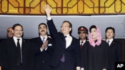 China's Prime Minister Wen Jiabao (C) waves as his Pakistani counterpart Yusuf Raza Gilani (2nd L) applauds after Wen's arrival to the joint sessions of the National Assembly and Senate in Islamabad, 19 Dec 2010