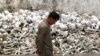 A Cambodian man walks past one of the many killing fields sites at a school on the outskirts of Phnom Penh.