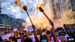 မီးတုတ်တွေကိုင်ဆောင်ပြီး ရန်ကုန်မှာ ဆန္ဒပြခဲ့ကြတဲ့ အမျိုးသမီးများ။ (ဇူလိုင် ၁၄၊ ၂၀၂၁)