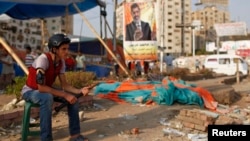 A supporter of deposed Egyptian President Mohamed Morsi guards outside one of the entrances of the sit-in area around Raba' al-Adawya mosque, where protesters are camping, east of Cairo, August 12, 2013. 