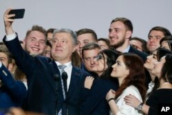 FILE - Ukrainian President Petro Poroshenko takes a selfie with supporters in Kyiv, Ukraine, Jan. 29, 2019.