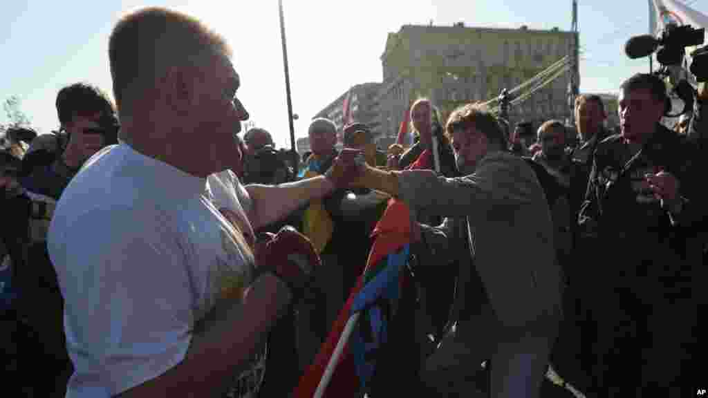 Demonstrators with opposing opinions clash at the beginning of an anti-war rally and march in downtown Moscow, Russia, Sept. 21, 2014. 