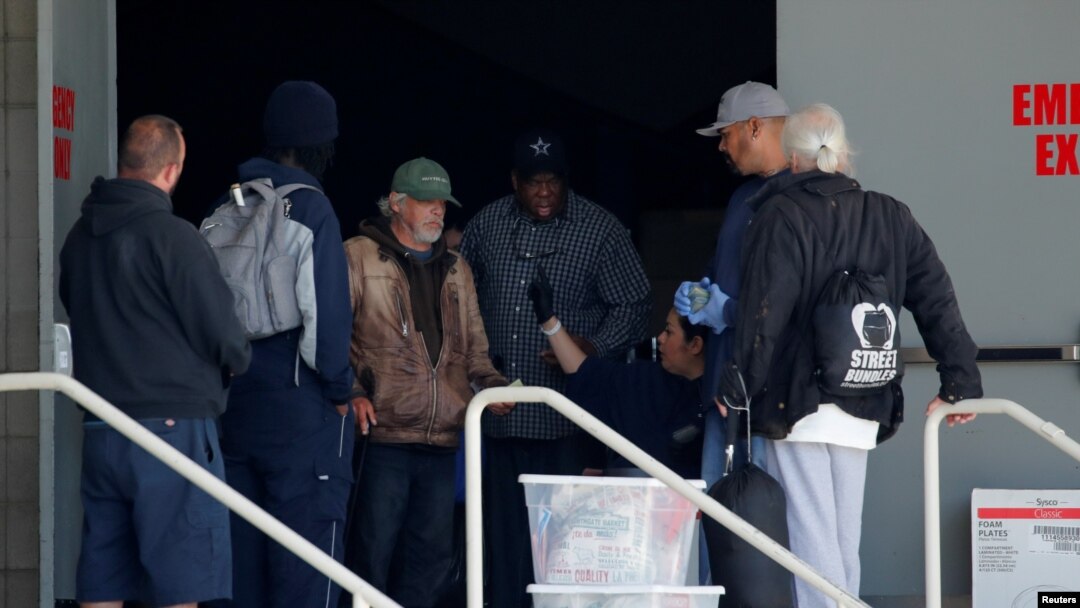 Para tunawisma tiba di gedung konvensi di pusat kota San Diego, California, yang diubah menjadi hunian sementara para tuna wisma di tengah wabah virus corona, 1 April 2020. (Foto: Reuters)