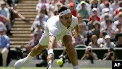 Petenis Swiss, Roger Federer, mengembalikan bola ke petenis Serbia, Dusan Lajovic, dalam laga tunggal putra putaran pertama turnamen tenis Grand Slam Wimbledon, di London, Senin, 2 Juli 2018.