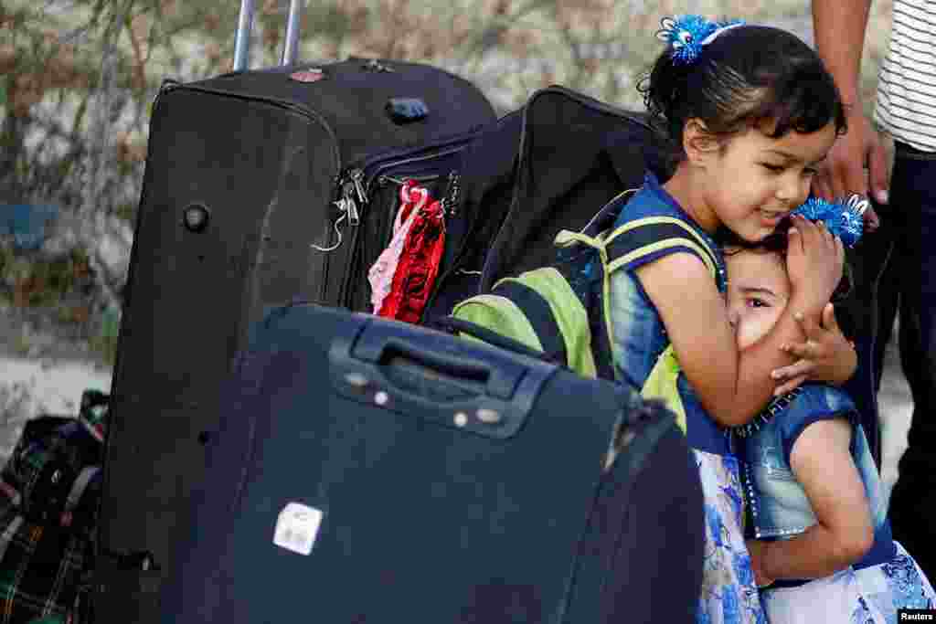 A girl hugs her sister before they leave the Palestinian Rafah border crossing with Egypt, which was reopened for the first time since March due to concerns about the spread of the coronavirus, in the southern Gaza Strip.