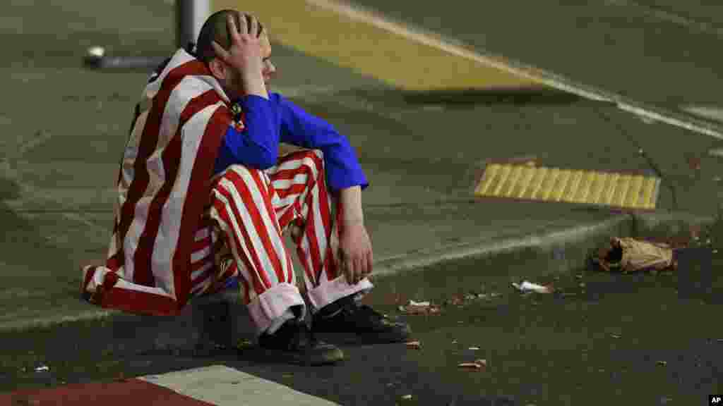 Un homme vêtu de rouge blanc et bleu est assis sur le trottoir lors d&#39;une manifestation contre le président élu Donald Trump, à Seattle &nbsp;le 9 novembre 2016.